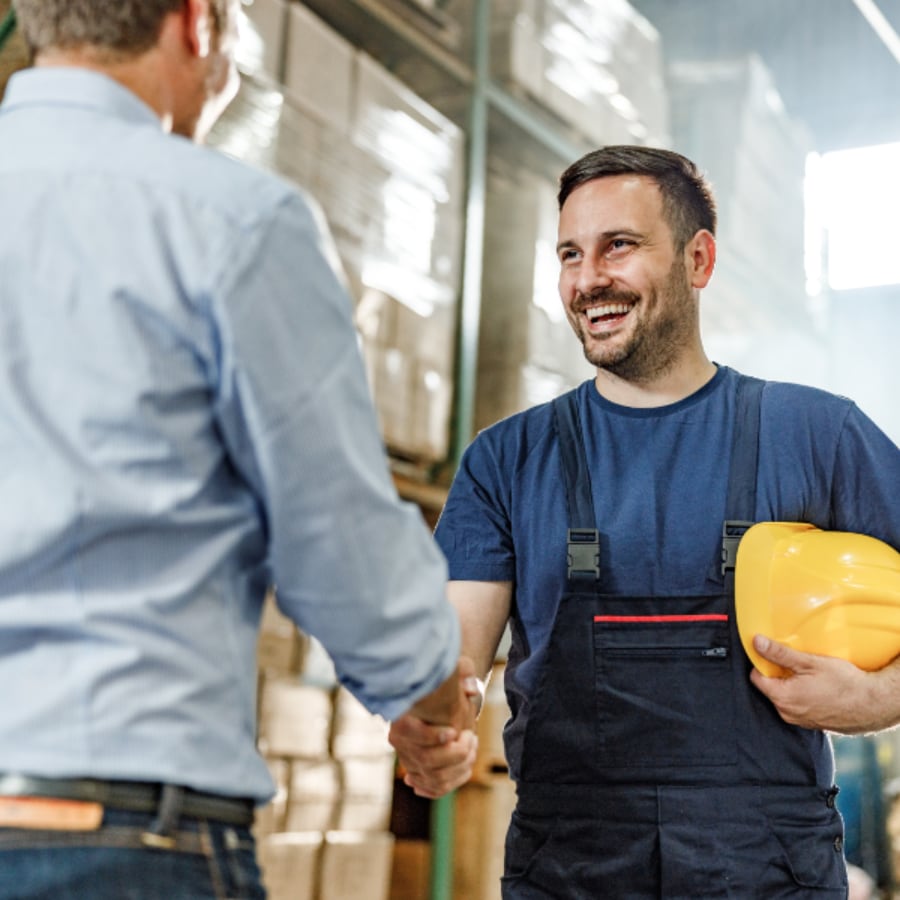 Warehouse workers shaking hands